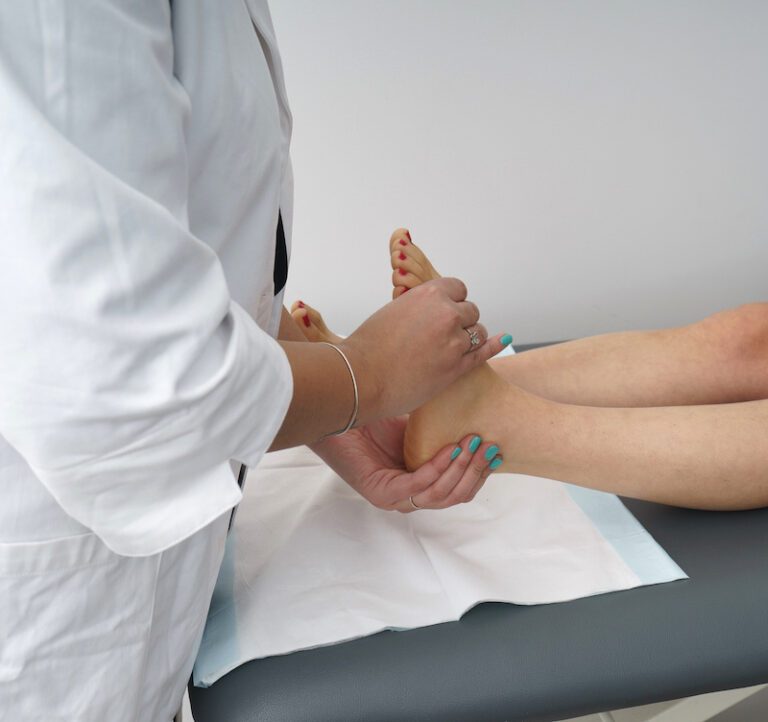 Podiatrist providing care to a patient's feet, addressing Achilles Tendinopathy through expert guidance and treatment.