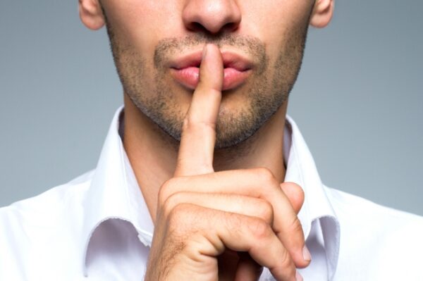 Man is acting of silence reaction with his finger on his mouse
