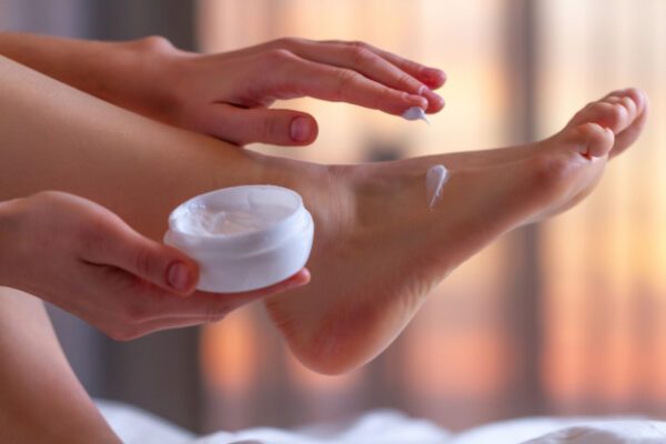 a girl use skin moisture on foot