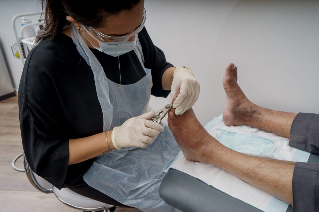 Podiatrist providing comprehensive care to a patient's foot during a general podiatry appointment, focusing on assessing and addressing various foot conditions for total care.
